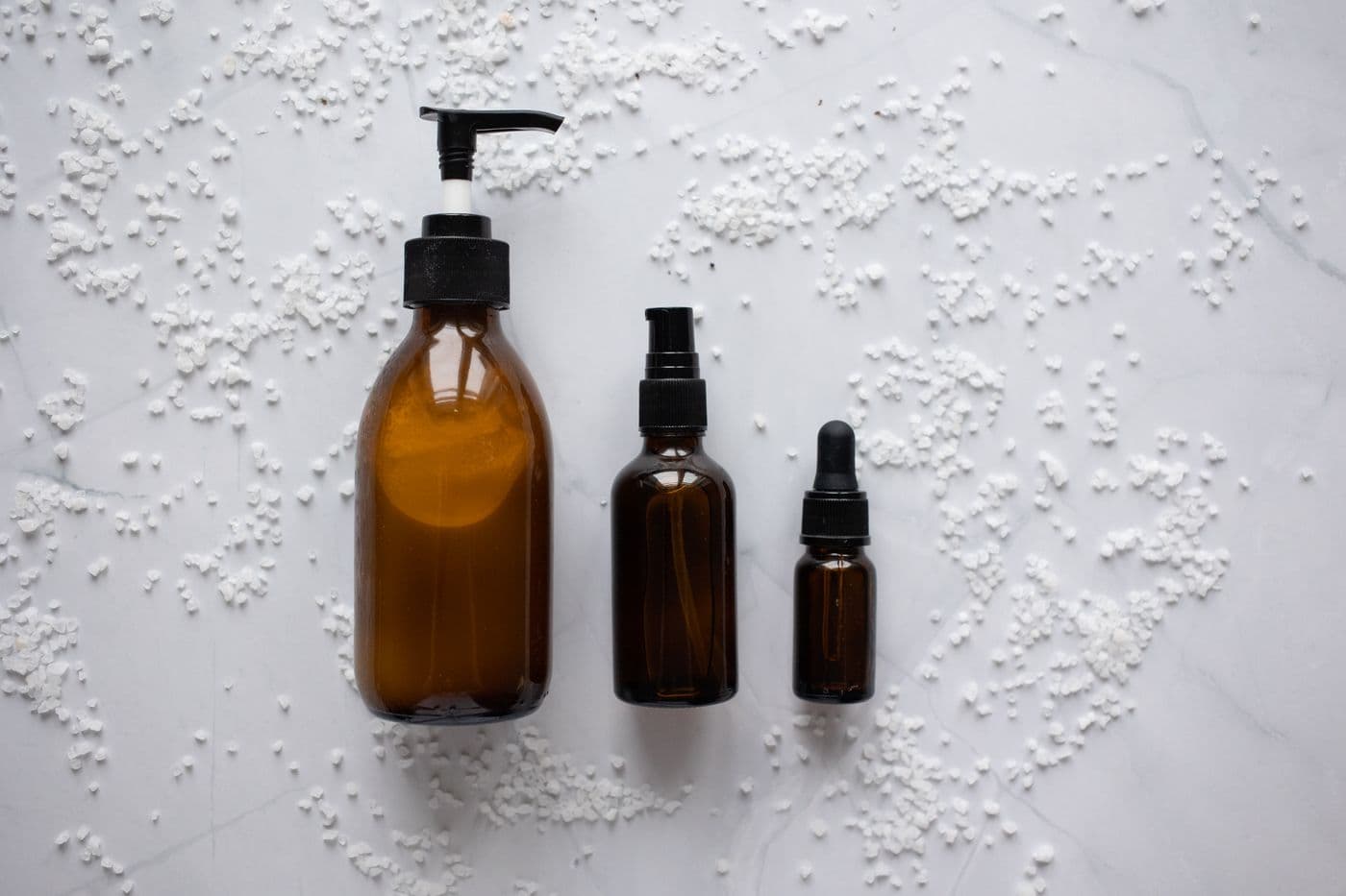 Minimal skincare products arranged on a soft neutral surface