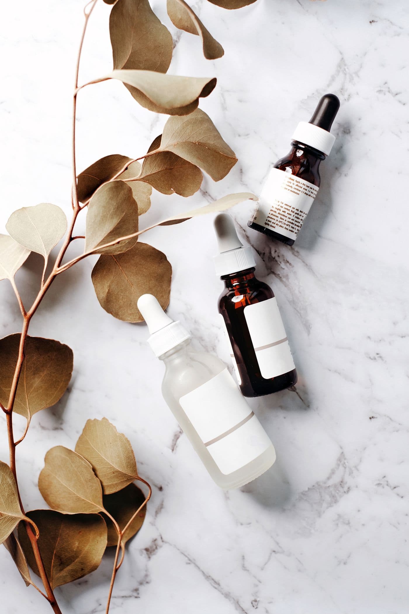 Luxury skincare bottles on marble with warm clinical light